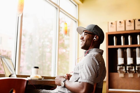 Young man sitting and smiling in a coffee shop.